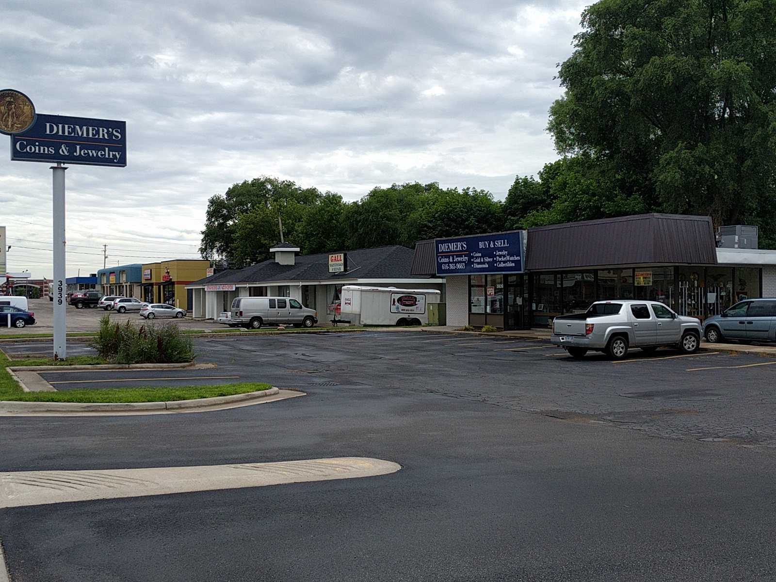 Diemer's Coins & Jewelry storefront at 3939 Plainfield Avenue NE, with its blue roadside sign and parking area.